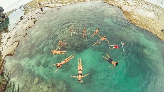 "a group of travelers enjoy floating in the rock pools o Magpupungko"